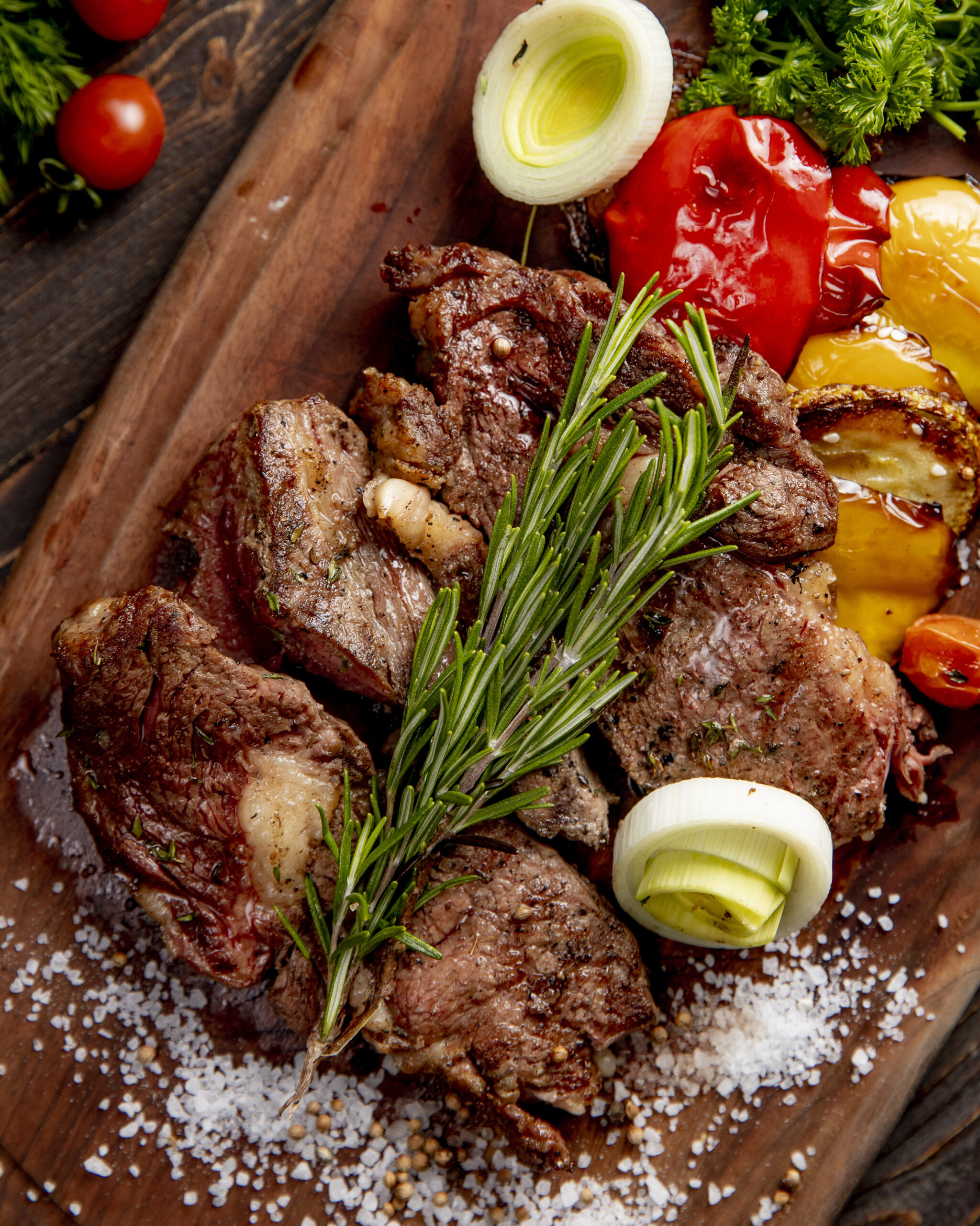 fried meat served with grilled vegetables onion and  rosemary sprig